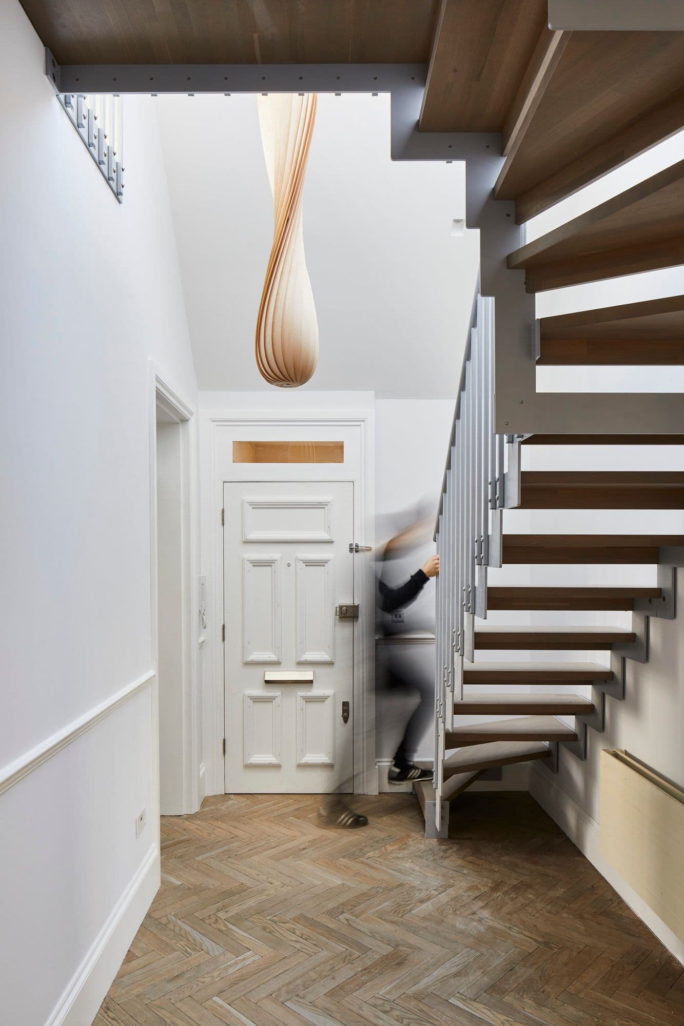 BPM17-Victorian-Penthouse-London-Chiswick-Hallway-Front-Door-Italian-Staircase-Herring-Bone-Parquet-with-Visitor_scaled.jpeg